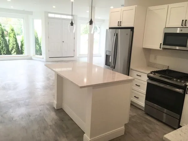 a kitchen with stainless steel appliances granite countertop a refrigerator and a stove