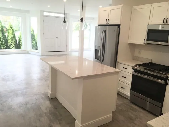 a kitchen with stainless steel appliances granite countertop a refrigerator and a stove