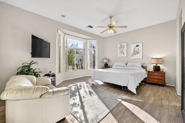 a spacious bedroom with a bed and a flat screen tv