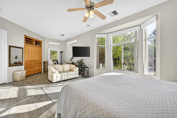 a bedroom with a bed flat screen tv and a large window