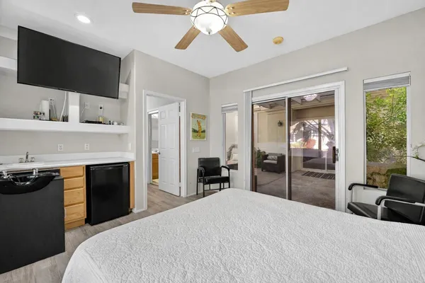 a bedroom with a bed and a flat tv screen on the dresser