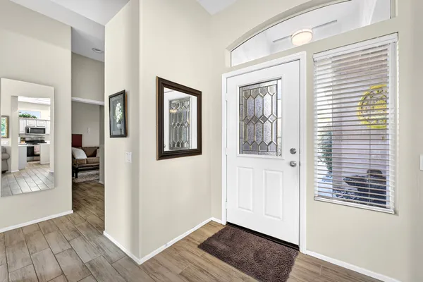 a view of an entryway with wooden floor and a kitchen