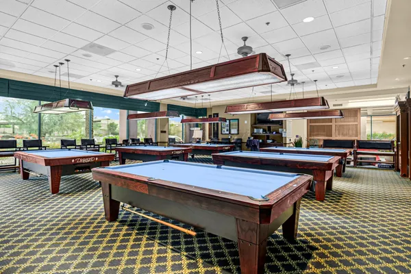 a room with pool table and windows