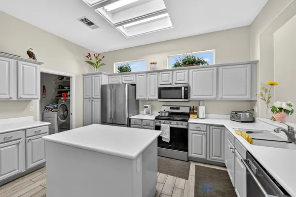 a kitchen with stainless steel appliances a stove refrigerator sink and cabinets