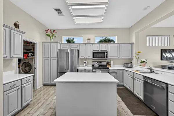 a kitchen with stainless steel appliances a stove refrigerator sink and microwave