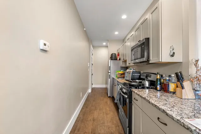 a kitchen with stainless steel appliances granite countertop a sink a stove top oven a refrigerator and dishwasher