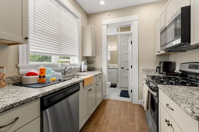 a kitchen with stainless steel appliances granite countertop a sink stove and refrigerator