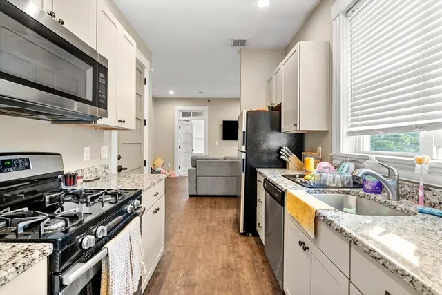 a kitchen with a sink stove top oven and cabinets