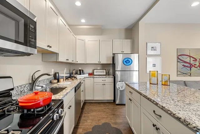 a kitchen with stainless steel appliances granite countertop a sink stove and refrigerator