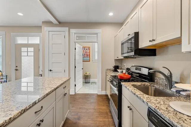 a kitchen with stainless steel appliances granite countertop a sink stove and cabinets