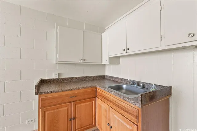 a kitchen with granite countertop white cabinets and a sink