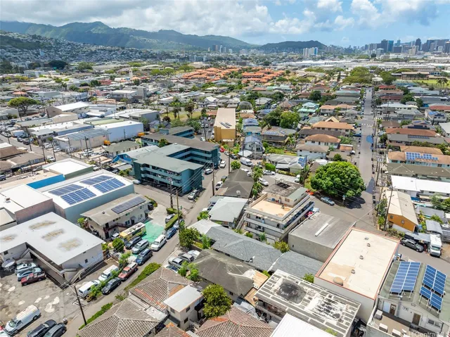 an aerial view of a city with lots of residential buildings and mountain view in back