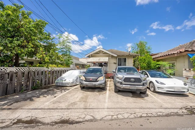 a front view of a house with cars parked