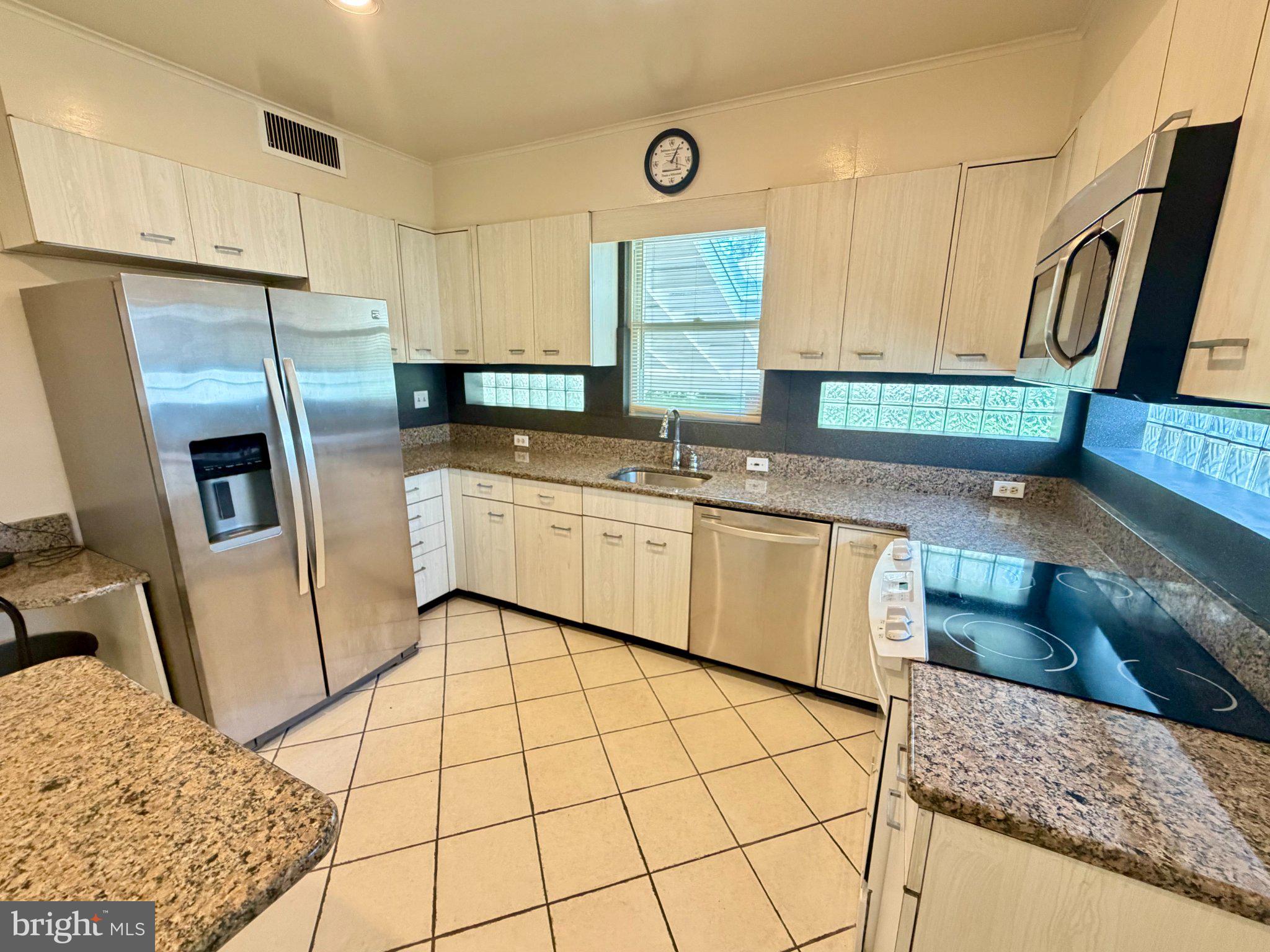 6318 Winner Avenue Baltimore, MD 21215 - Photo 19 of 75 a kitchen with stainless steel appliances granite countertop a sink stove and refrigerator