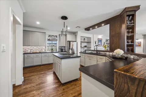 a large kitchen with cabinets table and chairs