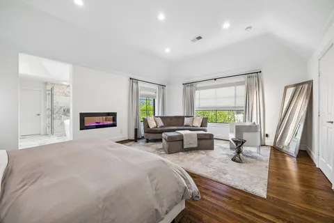 a spacious bedroom with a bed a couch and a window