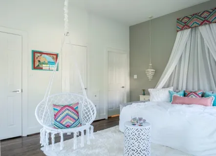 a spacious bedroom with a bed window and table in it