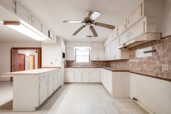 a kitchen with white cabinets a sink dishwasher and a stove with wooden floor