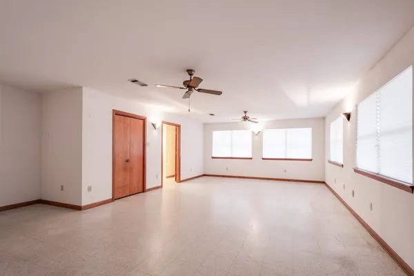 an empty room with windows and cabinet