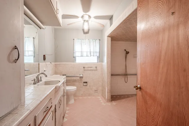 a bathroom with a double vanity sink toilet and shower