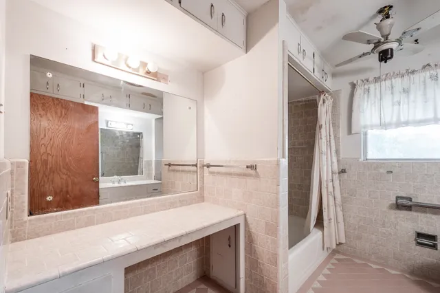 a bathroom with a tub sink and mirror