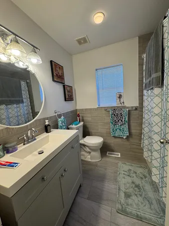 a spacious bathroom with a toilet sink and mirror