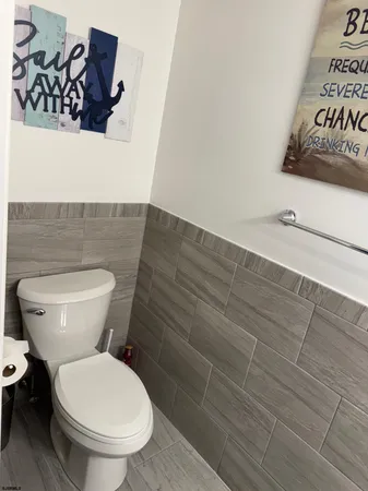 a white toilet sitting next to a wooden floor