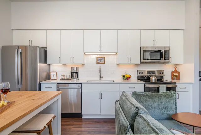 a kitchen with stainless steel appliances a stove a sink and cabinets