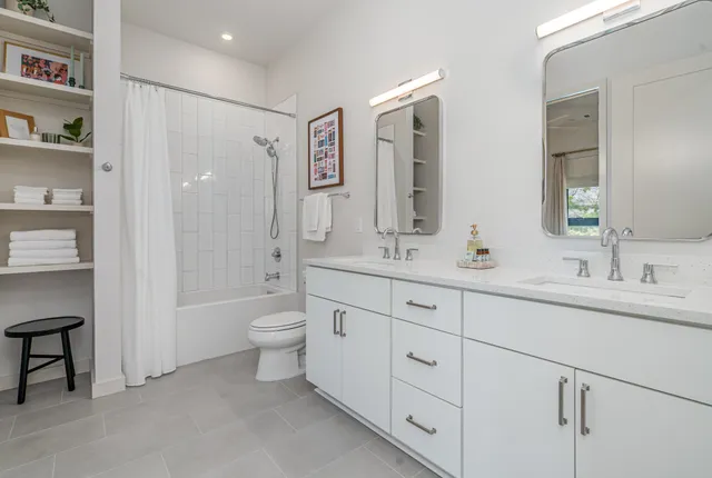a bathroom with double vanity sinks and a mirror