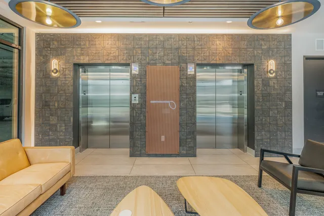 a dining hall with stainless steel appliances a table chairs and a large window