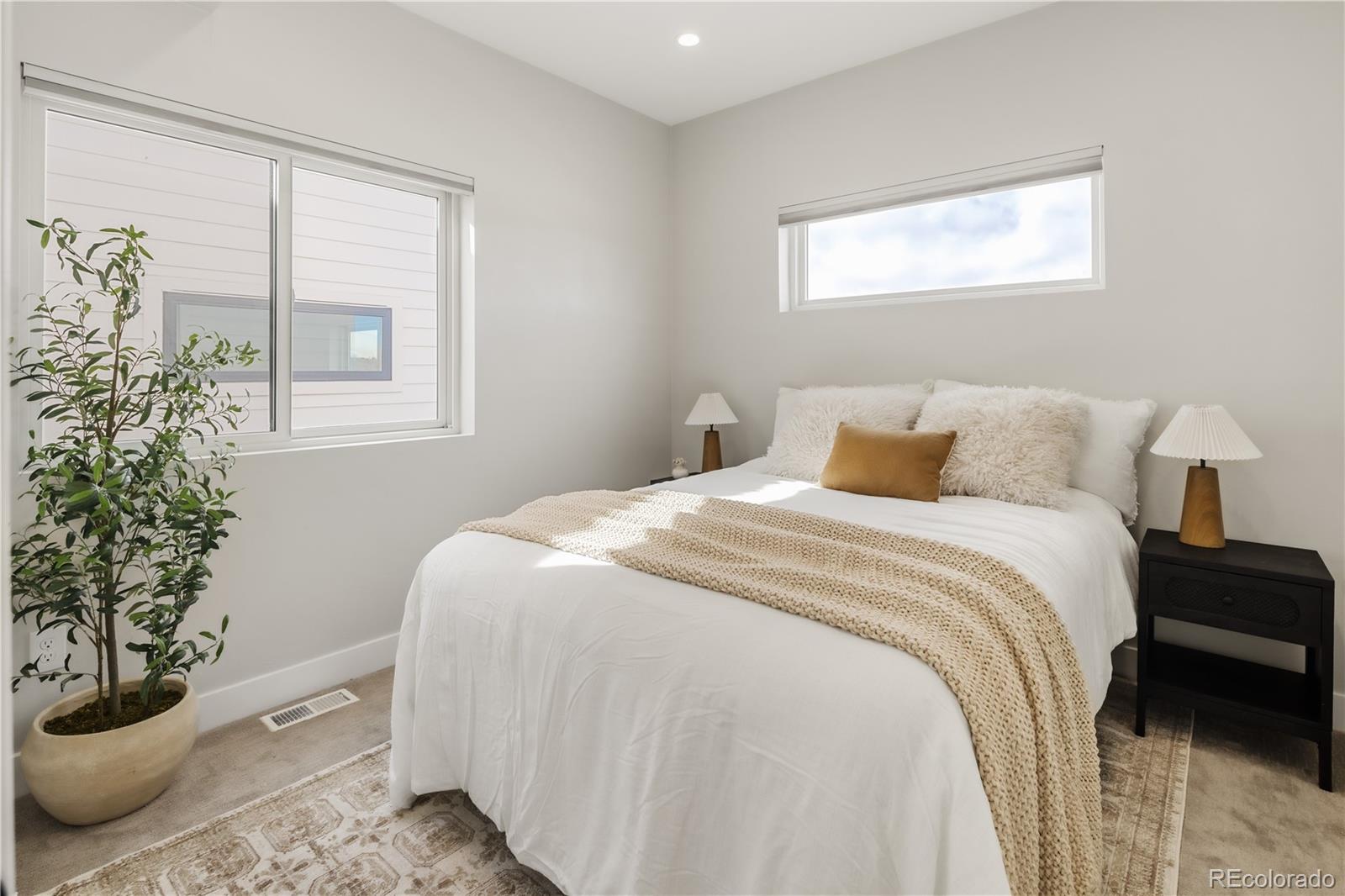 1467 Locust Street Denver, CO 80220 - Photo 17 of 23 a bedroom with a large bed and a potted plant