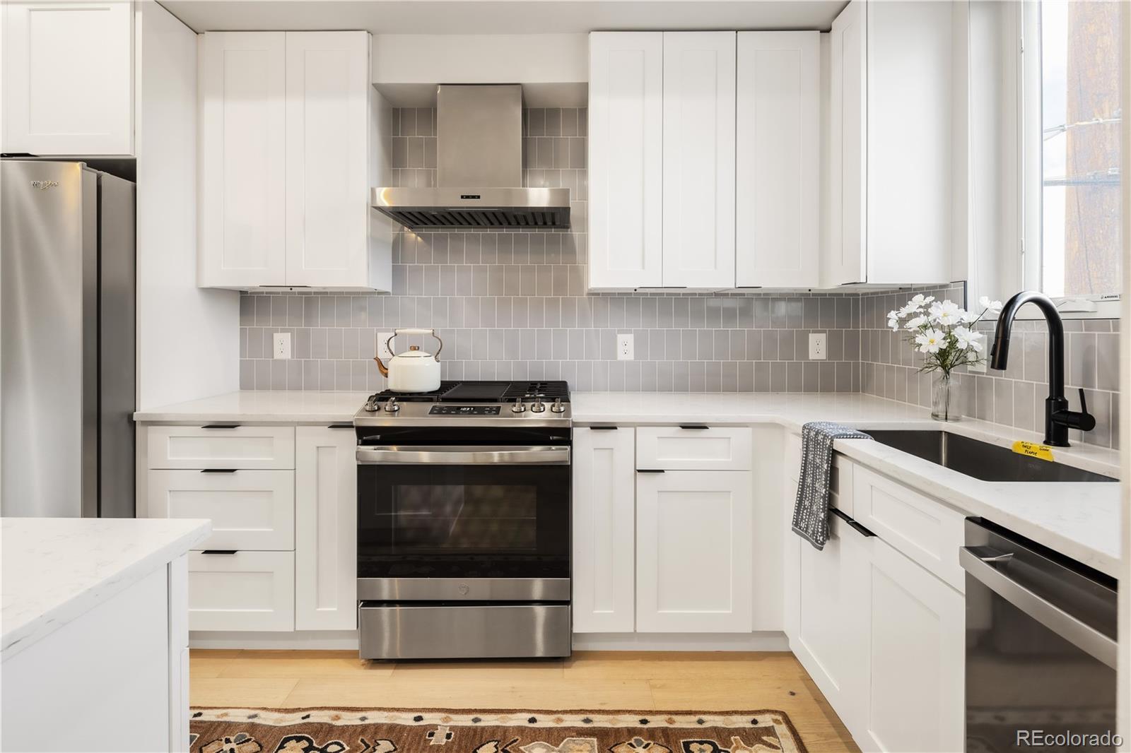 1467 Locust Street Denver, CO 80220 - Photo 18 of 23 a kitchen with stainless steel appliances a stove a sink and a refrigerator