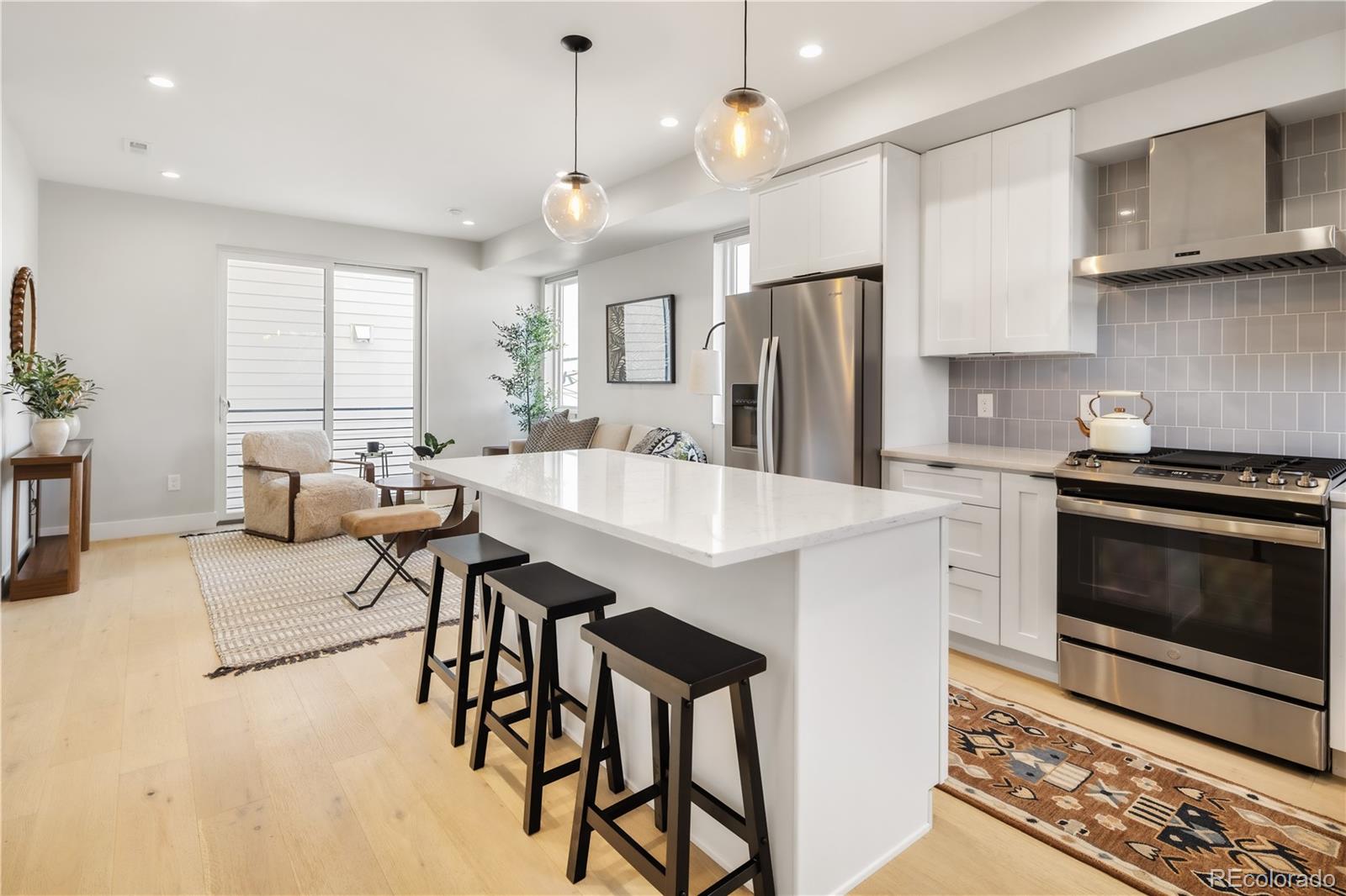 1467 Locust Street Denver, CO 80220 - Photo 9 of 23 a kitchen with stainless steel appliances kitchen island granite countertop a stove a sink a refrigerator and a microwave