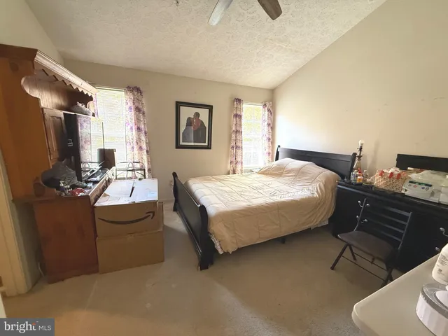 a bedroom with a bed desk and chair