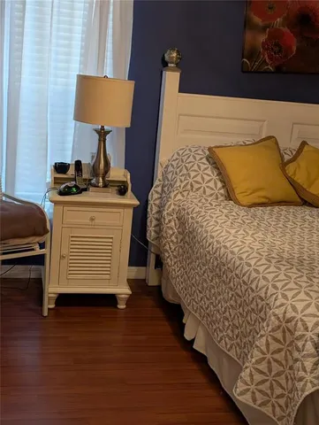 a bedroom with a bed and wooden floor