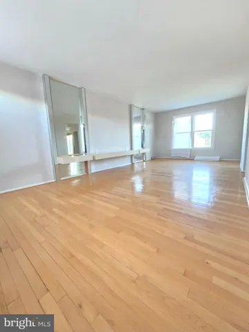 an empty room with wooden floor and window