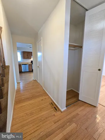 a view of a hallway with wooden floor and a fireplace