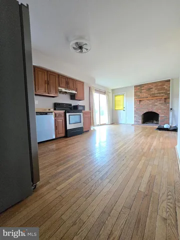 a living room with stainless steel appliances furniture a fireplace and a flat screen tv