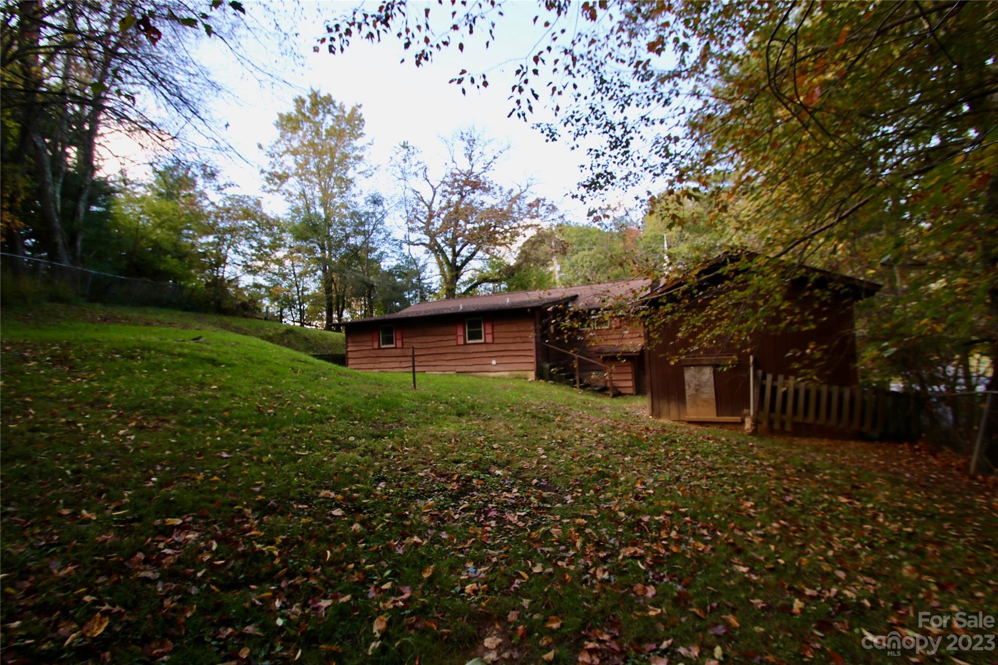 2872 Hyder Mountain Road Clyde, NC 28721 - Photo 19 of 29 a view of a backyard with large trees