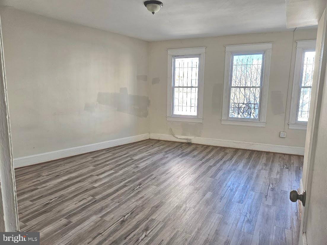 1648 Columbia Road Northwest, Unit B Washington, DC 20009 - Photo 7 of 15 an empty room with wooden floor and windows