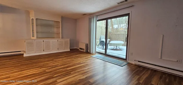 a view of a room with wooden floor and windows