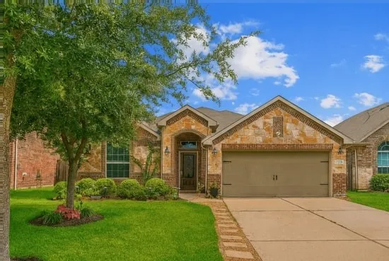 a front view of a house with a garden and yard