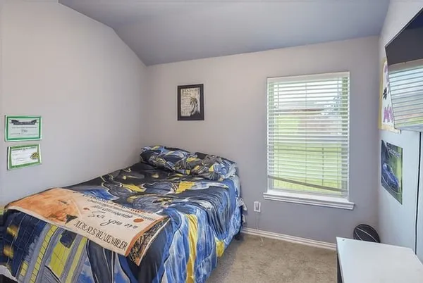 a bedroom with a bed next to a window