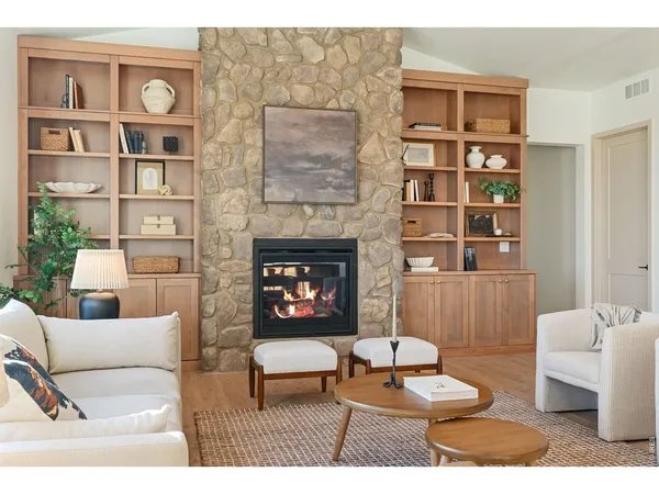 a kitchen with stainless steel appliances kitchen island granite countertop a table chairs in it and wooden floors