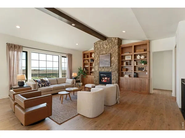 a living room with fireplace furniture and a large window
