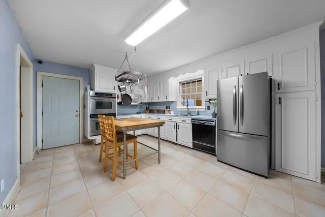 a kitchen with stainless steel appliances a refrigerator a stove a sink and a refrigerator