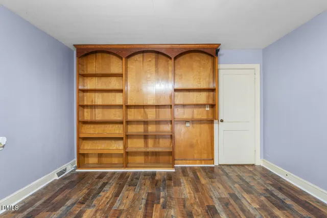 a view of empty room with wooden floor and door