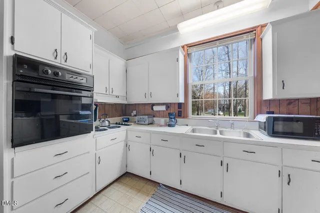 a kitchen with cabinets appliances a sink and a window