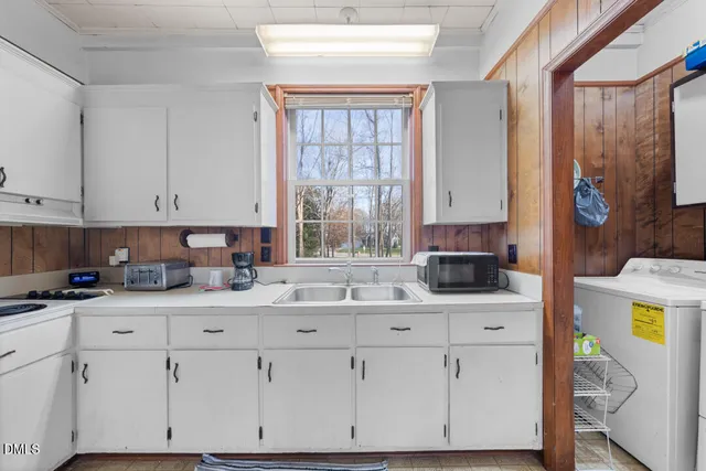a kitchen with granite countertop a sink a stove a microwave and cabinets
