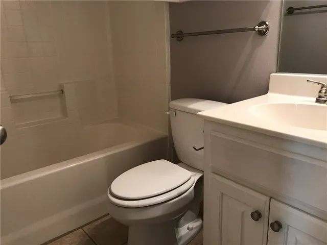 a white toilet sitting next to a bath tub